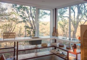 a kitchen with large windows and a counter with a sink at Tropical Design Stay near Playa Avellanas with Rooftop Terraces in Santa Cruz