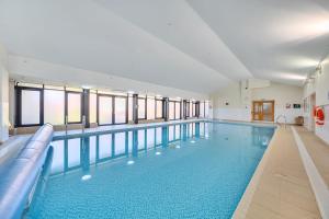 a large swimming pool in a building at Marine Court Three Bedroom Second-floor Apartment 34 in Littlehampton