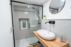 a white bathroom with a sink and a shower at Casa dos Bonecos in Estremoz