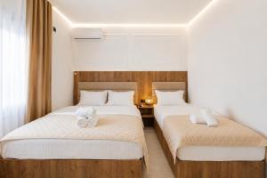 two beds in a hotel room with towels on them at Apartmani Centar in Igalo
