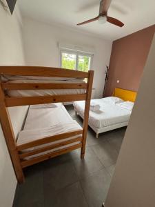 two bunk beds in a room with a ceiling fan at Le Moutchico in Lacanau