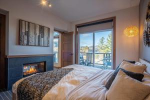 a bedroom with a fireplace and a bed at Suite with mountains view & Resort access in Lac-Superieur