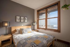 a bedroom with a bed and a large window at Suite with mountains view & Resort access in Lac-Superieur