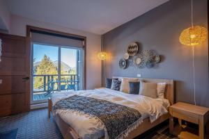 a bedroom with a bed and a large window at Suite with mountains view & Resort access in Lac-Superieur