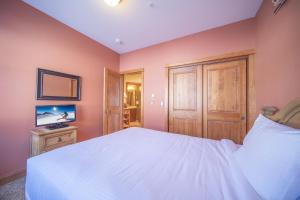 a bedroom with a white bed and a tv at Antlers Gulch 303 by SummitCove Lodging in Colorado in Keystone +41 photos