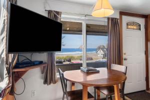 オーシャンサイドにあるOceanside Ocean Front Cabinsのテーブルと薄型テレビのあるリビングルーム