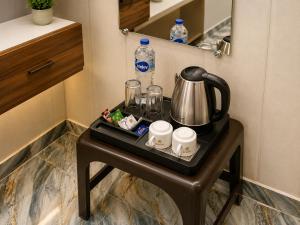 a small table with a tea kettle and cups on it at Shri Raghav Palace Hotel Ayodhya in Ayodhya