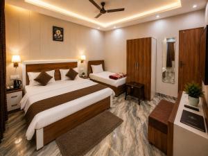 a hotel room with two beds and a bathroom at Shri Raghav Palace Hotel Ayodhya in Ayodhya +19 photos