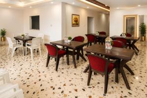 a restaurant with wooden tables and red chairs at Shri Raghav Palace Hotel Ayodhya in Ayodhya