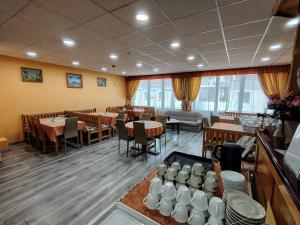 a dining room with tables and chairs and windows at City Hotel Siófok in Siófok +49 photos