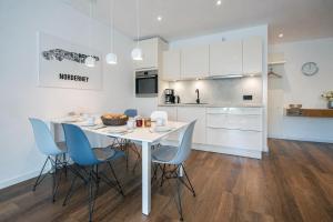 a kitchen and dining room with a white table and chairs at Wohnart - Fewo 1 Wohnstil in Norderney +7 photos