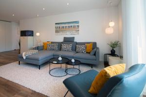 a living room with a blue couch and a table at Wohnart - Fewo 1 Wohnstil in Norderney