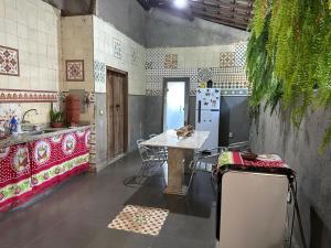 a kitchen with a table and a refrigerator at Chácara do Waltinho in Contagem +21 photos