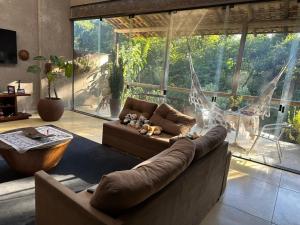 a living room with a couch and a large window at Chácara do Waltinho in Contagem