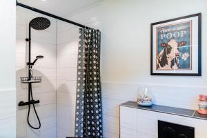 a bathroom with a shower with a shower curtain at Fördezauber - Ruhiges Ferienhaus mit eingezäuntem Garten und Kamin in Bönstrup +41 photos