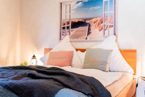 a bedroom with a bed with a picture of the beach at Fördezauber - Ruhiges Ferienhaus mit eingezäuntem Garten und Kamin in Bönstrup