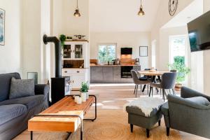 a living room with a couch and a table at Fördezauber - Ruhiges Ferienhaus mit eingezäuntem Garten und Kamin in Bönstrup