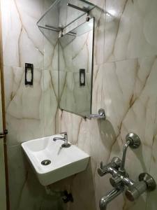 a bathroom with a sink and a mirror at Hotel Bkc Palace Kurla in Mumbai