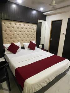 a bedroom with a large bed with red pillows at Hotel Bkc Palace Kurla in Mumbai +29 photos