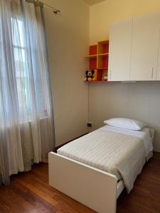 a bedroom with a white bed and a window at The Fruit House in Cascina