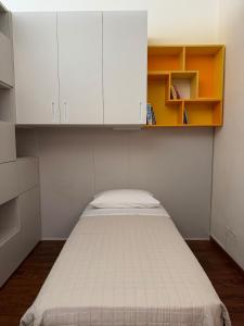 a small bedroom with a bed and white cabinets at The Fruit House in Cascina