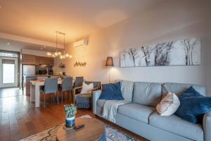 a living room with a couch and a table at Condo overlooking Lac Superieur & mountain views in Lac-Superieur