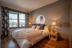 a bedroom with a large bed and a window at Condo overlooking Lac Superieur & mountain views in Lac-Superieur
