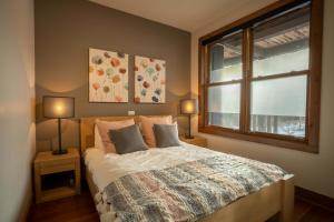 a bedroom with a bed with two lamps and a window at Condo overlooking Lac Superieur & mountain views in Lac-Superieur