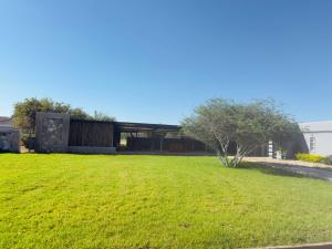 a green yard with a building in the background at plot 38 self catering apartment and camping in Khemsbok