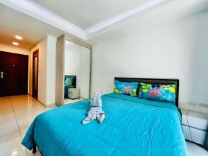 a bedroom with a blue bed with a stuffed animal on it at Laguna Beach Resort 2 Pattaya in Jomtien Beach +29 photos