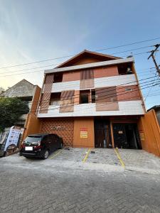 a building with a car parked in front of it at Sendja Residence in Semarang