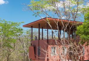 a person standing on the balcony of a building at Tropical Design Stay near Playa Avellanas with Rooftop Terraces in Santa Cruz