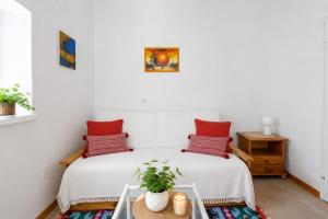a bedroom with a bed with red pillows and a table at Giardino del Convento in Domaso +23 photos