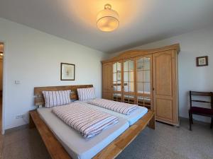 a bedroom with a large bed with a wooden headboard at Casa Calvin in Unteruhldingen