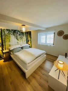a bedroom with a large bed and a chandelier at Ferienhaus am Bächle in Breitnau