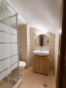 a bathroom with a sink and a toilet and a mirror at Azure Sea House in Avlemonas