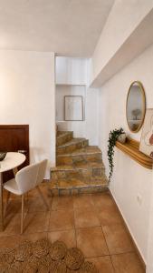 a staircase in a room with a table and a mirror at Azure Sea House in Avlemonas