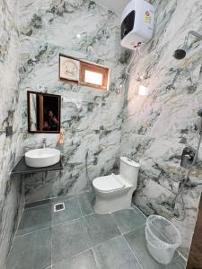 a bathroom with a white toilet and a sink at Singh Kainchi Dham Villa in Bhowāli +14 photos