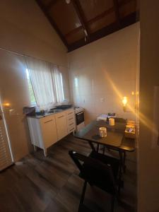 a small kitchen with a table and a dining room at Chale Amarelo Aconchegante com lareira no bosque e estacionamento grátis in Extrema