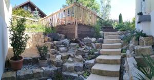 a garden with rocks and a wooden stairway at Finca Ludwig am Forggensee in Rieden
