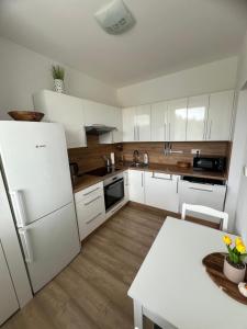 a kitchen with white cabinets and a white counter top at Apartmán Třinec in Třinec