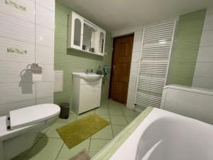 a bathroom with a tub and a toilet and a sink at Apartmán Stráne in Martin +5 photos