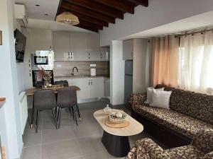a living room with a couch and a table and a kitchen at Angie Apartment in Ierissos