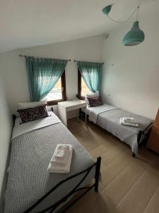 a bedroom with two beds and a desk and a window at Angie Apartment in Ierissos