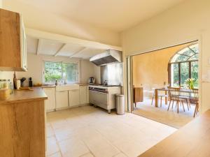 a kitchen with a stove and a dining room at Mas provençal - Idéal familles & amis - Piscine privée - 3 suites - Avignon & Châteauneuf-du-Pape - Parking privé gratuit in Bédarrides