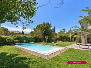 a swimming pool in the yard of a house at Mas provençal - Idéal familles & amis - Piscine privée - 3 suites - Avignon & Châteauneuf-du-Pape - Parking privé gratuit in Bédarrides