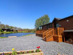 a house with a wooden deck and a pond at Lakeside Lodge in Preston