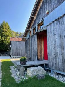 a wooden building with a red door on it at Sonnenchalet in Bodman-Ludwigshafen