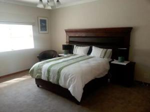 ein Schlafzimmer mit großem Bett und Fenster in der Unterkunft Spacious Garden Cottage in Johannesburg + 10 Fotos