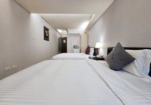 two large white beds in a hotel room at 意芙旅店 Ifinn Hotel in Taipei